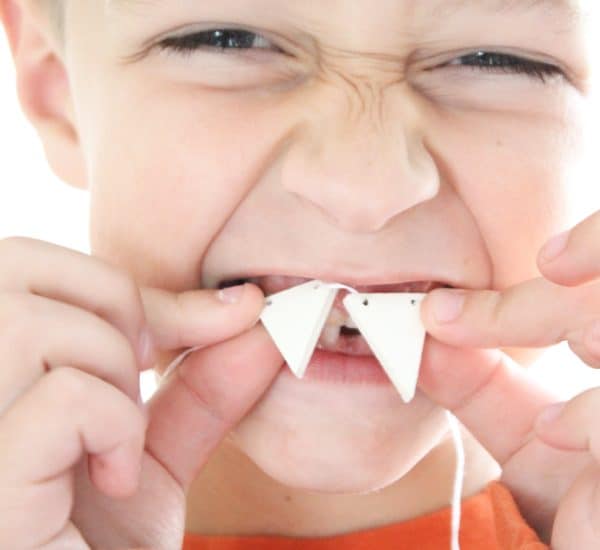 This DIY Fang Necklace is a fun kid's craft for Halloween! via createcraftlove.com