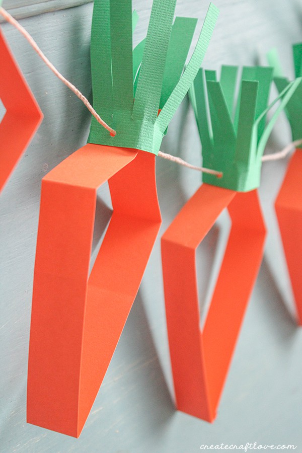 This Paper Carrot Garland is a great kids craft and can be done without a cutting machine! via createcraftlove.com
