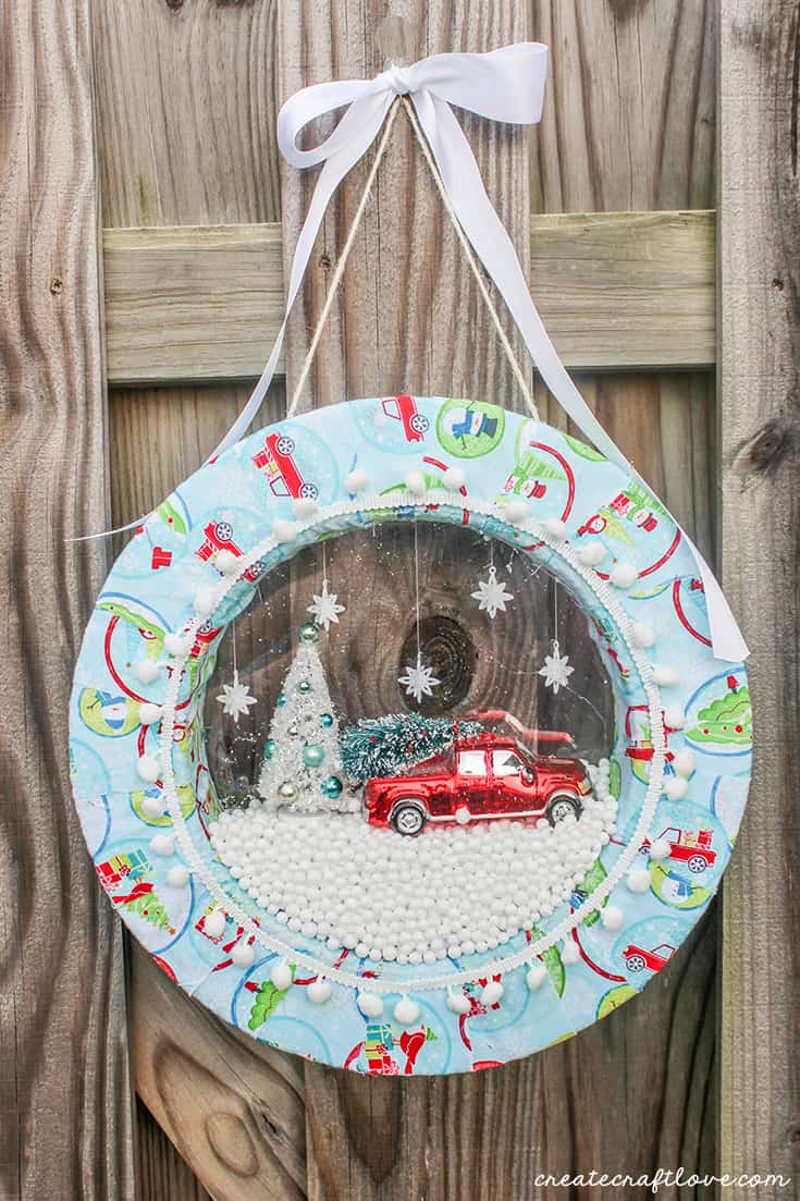 Hang your snow globe wreath with twine and ribbon to display for holiday guests!