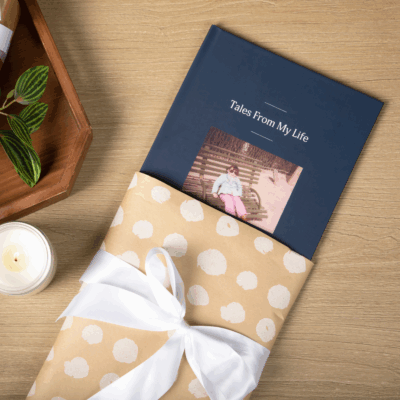 A life story Remento book in a gift wrapped sleeve with a white bow