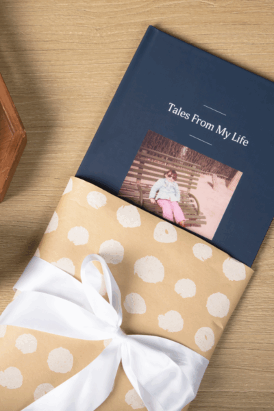 A life story Remento book in a gift wrapped sleeve with a white bow