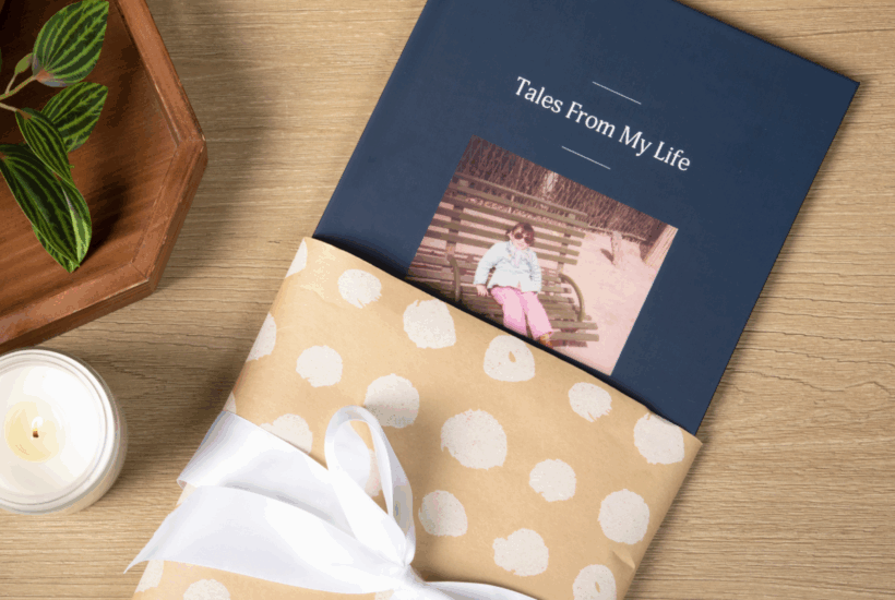 A life story Remento book in a gift wrapped sleeve with a white bow